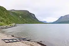 Un lac entouré de montagnes séparées par une vallée en U