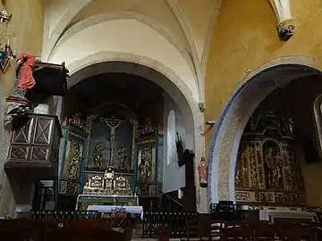 Le retable de la Crucifixion et le retable de la Vierge. À gauche, la chaire à prêcher et une statue représentant le martyre de saint Jean-Gabriel Perboyre.