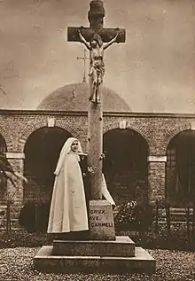 Thérèse de Lisieux devant une croix à écots