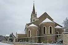 Photographie en couleurs d'un édifice religieux sous la neige.