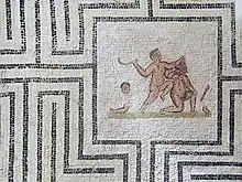 Représentation de Thésée au moment où il est en train de couper la tête du Minotaure ; la scène se passe au milieu d'un labyrinthe.