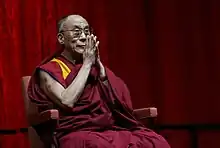 Photographie du dalaï-lama joignant les mains.