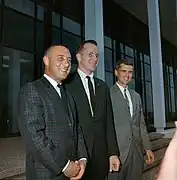 Photographie couleur des trois hommes d'équipage souriant et en costumes.