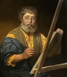 Peinture. Un homme barbu devant un chevalet peint une toile.