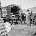 Le 5 octobre 1944, des militaires de l'armée du Royaume-Uni opérant alors en Belgique débarquent, sur un brancard, un blessé d’un camion ambulance qui l'a évacué vers un poste médical avancé.