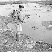 En Syrie, le 11 mai 1942, un militaire britannique pulvérise une mare avec du vert de Paris (acéto-arsénite de cuivre) pour y tuer larves et pupes de moustiques et ainsi prévenir le risque paludéen.