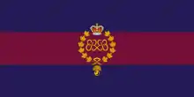 Image en couleurs d'un drapeau composé de trois bandes horizontales, les deux bandes extérieures bleues et la bande du centre violet et portant au centre un insigne militaire