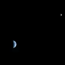La Terre et la Lune apparaissent en croissants devant un fond noir.