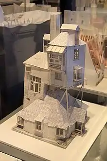 Une maquette en carton fin représentant une maison dont la structure défie la gravité.