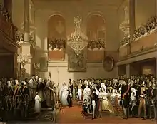 Peinture à l'huile représentant Léopold 1er et Louise d'Orléans lors de leur mariage, les officiels en grand apparat sont en nombre, les galeries aux étages sont combles, la scène est éclairée par d'imposants lustres or et cristal.