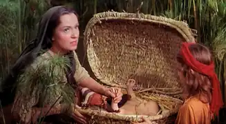 Martha Scott (Yochebed) mettant son fils Moïse bébé (Fraser Heston) dans son panier d’osier ; à droite Heather, la fille de Henry Wilcoxon, sœur de Moise dans le film.