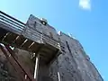 Le donjon en contre-plongée avec son escalier extérieur et son mâchicoulis.