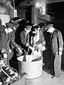 Le capitaine d'un navire ravitailleur de la Home Fleet mélange le Christmas pudding de 1942, tandis que le first lieutenant ajoute du rhum (Scapa Flow, 12 décembre 1942)