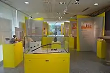 Vue générale d'une exposition avec au premier plan des vestiges d'activité métallurgique et à gauche une vitrine exposant des céramiques.