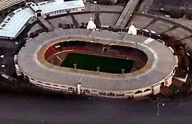 Vue aérienne d'un stade sportif aux tribunes couvertes.