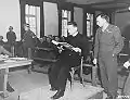 Le prêtre polonais Theodore Korcz (à gauche) assisté du procureur en chef Denson fait la lecture du protocole des expériences sur le paludisme le 22 novembre 1945