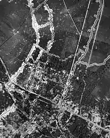 Photographie en noir et blanc d'un terrain vu de haut. Les lignes blanches des tranchées bigarrent l'image.