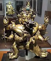 Photo d'une statue dorée dans un musée représentant un personnage de petite taille avec plusieurs bras et plusieurs jambes.