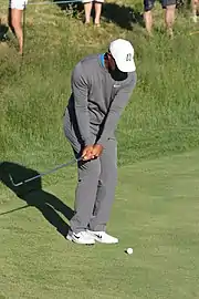 Le golfeur balance son club vers l'arrière tout en gardant les yeux sur le balle.