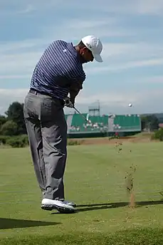 Un jour de golf vient de frapper un balle avec un club.