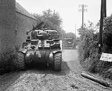Photo de chars américains Cromwell et Sherman sur une petite route dans les environs de Tilly-sur-Seulles