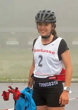 Une jeune femme vu de face en train de sourire.