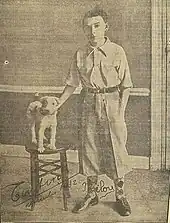 Photo en noir et bland d'un garçon habillé en Tintin avec un chien figurant Milou.