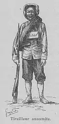Dessin représentant un homme asiatique en uniforme, debout et tenant un fusil. Un sous-titre indique « tirailleur annamite ».
