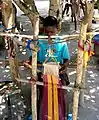 Jeune tisserand fabriquant un kenté.