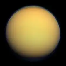 image de Titan, d'une teinte jaune et d'apparence floue du fait de son atmosphère.