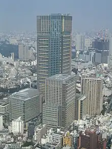Photo d'un gratte-ciel entouré de plus immeubles de taille moyenne.