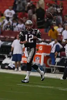 Tom Brady lors d'un échauffement s'apprêtant à recevoir un ballon.