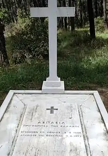 Photographie en couleur d'une pierre tombale sur laquelle sont inscrits des mots grecs.
