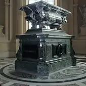 Photographie d'un monument funéraire en marbre composé de deux parties : un sarcophage reposant sur un soubassement.