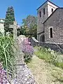 Au premier plan, la tombe de l'abbé, Raymond Escribe, située dans l'ancien cimetière attenant à l'église.