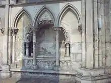Photo du tombeau roman de l'archevêque Hugues d'Amiens derrière des arcatures gothiques
