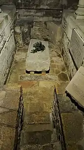 Photographie d'un élément de sarcophage de pierre dans une crypte