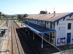 Vue depuis la passerelle :Le bâtiment voyageurs et les voies en direction d'Aiguillon.