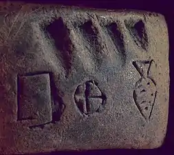 Petite tablette en argile comprenant des signes proto-cunéiformes et numériques.
