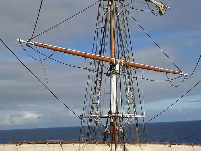 Sur cette vergue privée de sa voile on distingue aux extrémités les balancines qui montent vers le haut, les bras qui partent vers l'arrière (et passent sans doute par une poulie de renvoi fixée sur le mât d'où la photo est prise), et les marchepieds, cordages pendant sous la vergue, utilisés par les gabiers pour travailler sur cette partie du gréement.