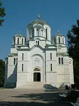 Photographie en couleur montrant une église de style oriental avec trois coupoles et des murs très blancs.
