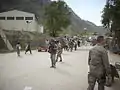Les 82e soldats et les unités logistiques de la Force opérationnelle interarmées combinées marchent dans la zone frontalière de Torkham avec le directeur du Centre d'opérations de déploiement et de distribution du CENTCOM, major général de l'armée de l'air américaine, Robert McMahon, le 25 mars 2010 à Torkham, en Afghanistan.