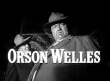 Hans Quinlan, le flic pourri, est gonflé par l’abus d’alcool (cadré en contre-plongée) dans La Soif du mal, réalisé par Orson Welles.