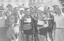 Photographie en noir et blanc montrant un groupe de coureurs à l'arrivée d'une étape.