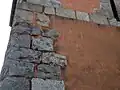 Impact de boulets sur l'arête aux chaînages d'angles en granit.