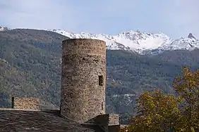 Tour arrondie devant un paysage montagneux.