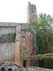 Photo couleur d'une tour à plateforme plane servait de belvédère. Les traces de briques tronquées sur le côté laissent entrevoir une partie des défenses démolies. Le clocher de la cathédrale apparait en arrière-plan.