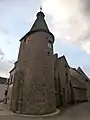 Tour de l'horloge de Bellegarde-en-Marche à l'aurore (vue de l'extérieur du bourg, juillet 2019). Anciennes fortifications visible derrière la tour.