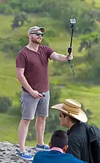 Un homme se prend en photo en utilisant une perche à selfie.