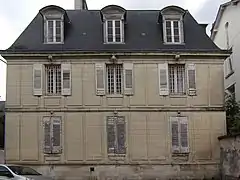 Photographie en couleurs de la façade d'un bâtiment à étage et comble.